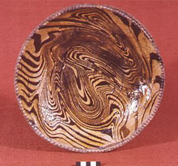Fig 7 Press-moulded dish with two concentric circles in relief near the centre and a dentelle rim. Interior surface has dark brown slip-trailed lines joggled on a white ground. Excavated from the kiln site at Brookhill Pottery. Copyright Peter Davey